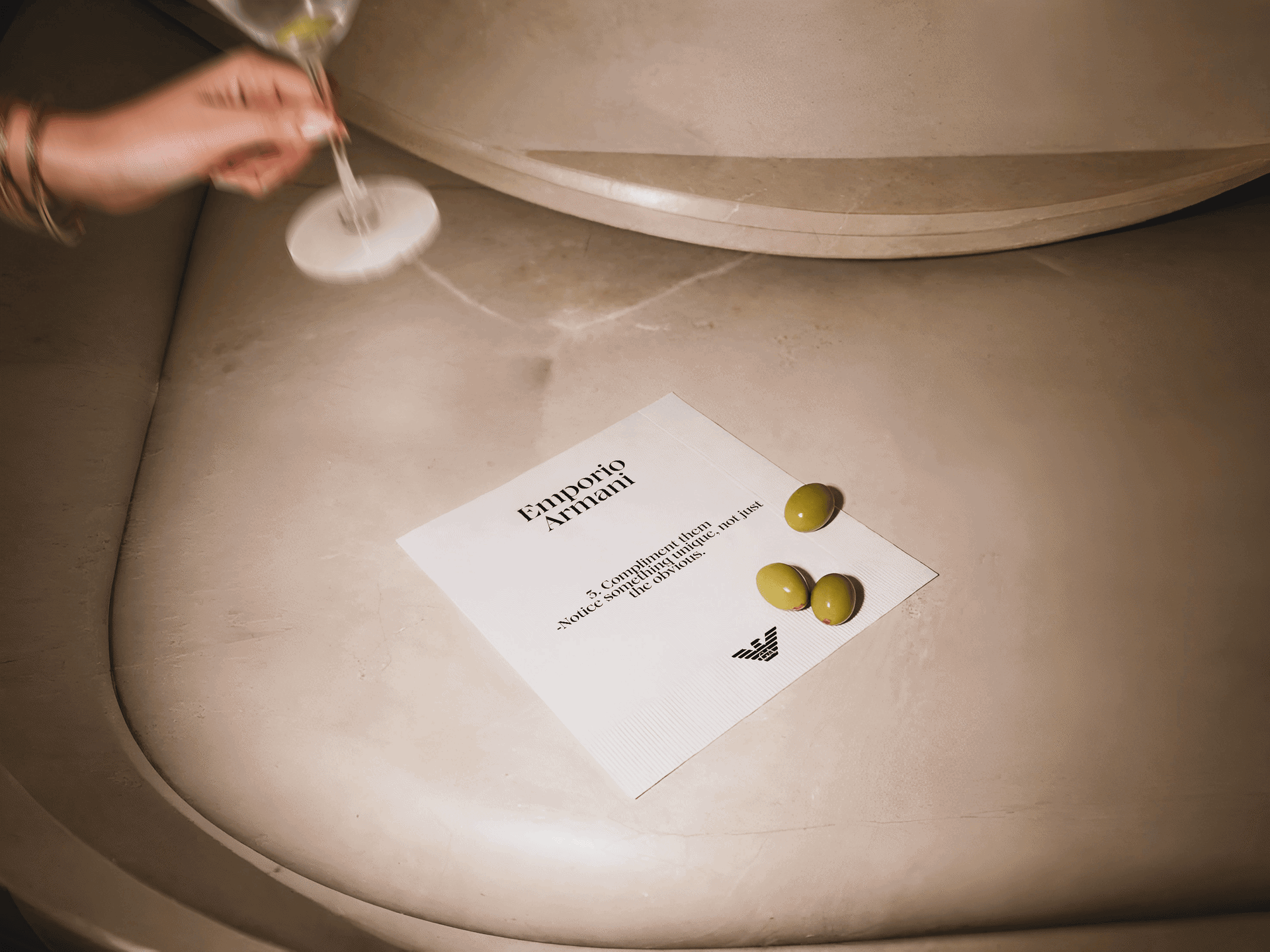 Cocktail napkin and martini at a restaurant table for the Emporio Armani Unforgettable Night fragrance campaign